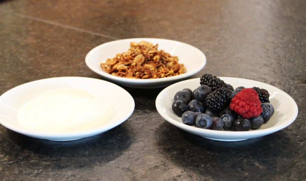 Joghurt und Beeren auf unterschiedlichen Tellern